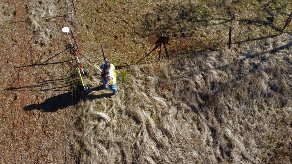 Land with man surveying equipment